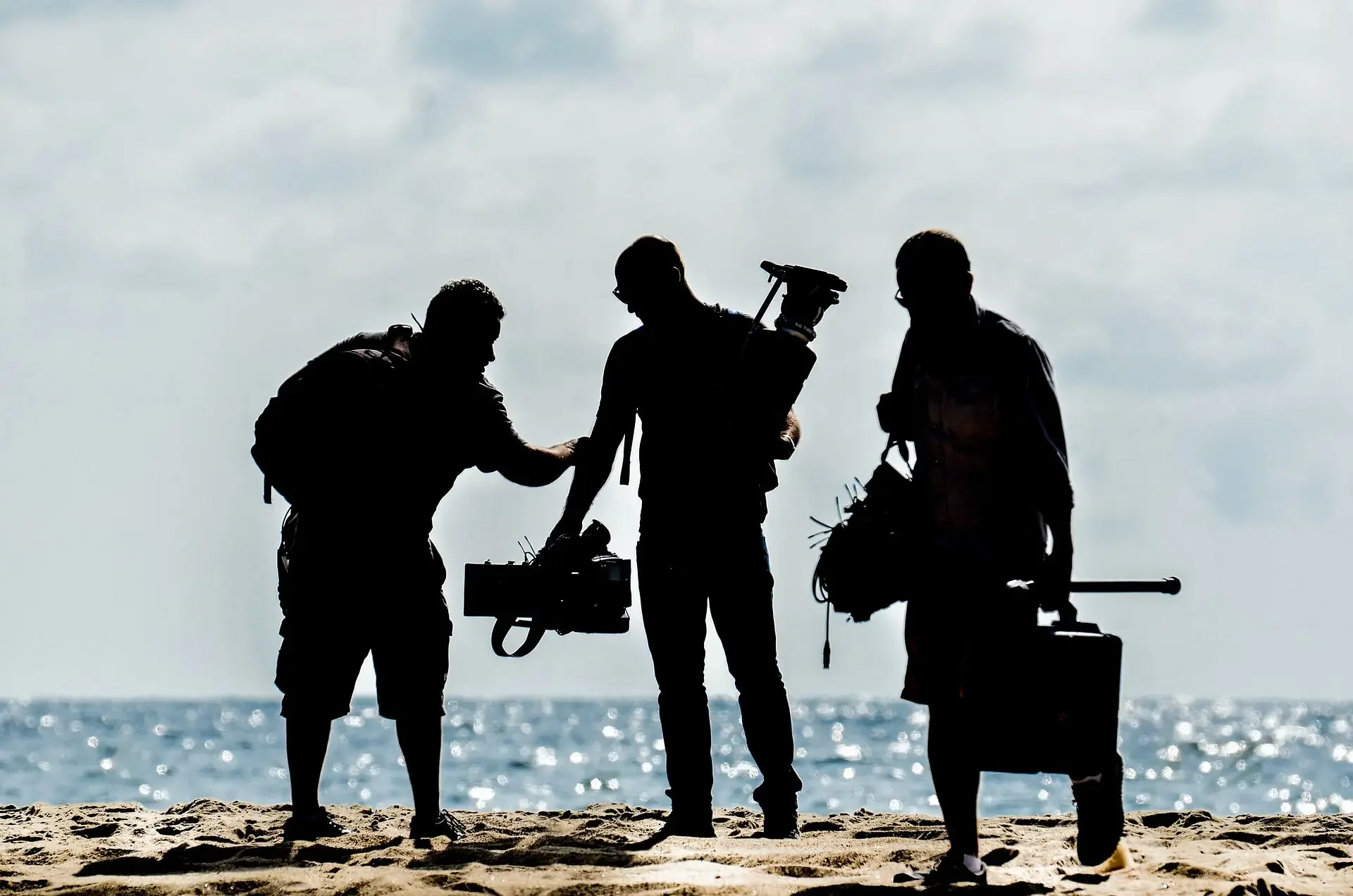 A group of video producers on the beach, shooting a corporate video.